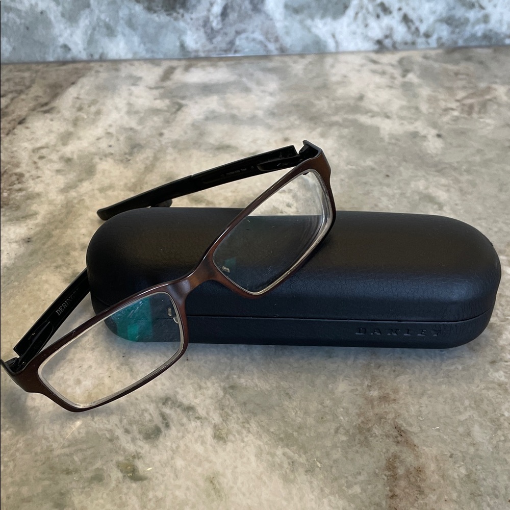 Oakley copper brown men’s glasses with Oakley hard shell case and cloth bag.